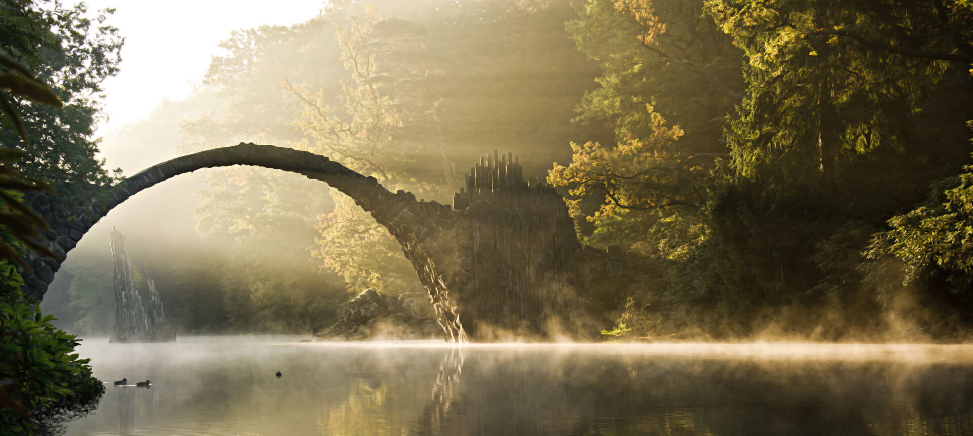 Die geheimnisvolle Teufelsbrücke im Azaleen- und Rhododendronpark Kromlau im Nebel; würdevolle Erinnerungsorte durch Bestattung Hinz.